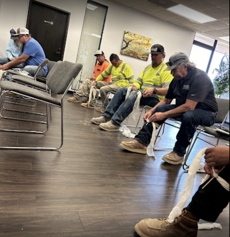 group of employees learning first aid from a-b-cpr training.