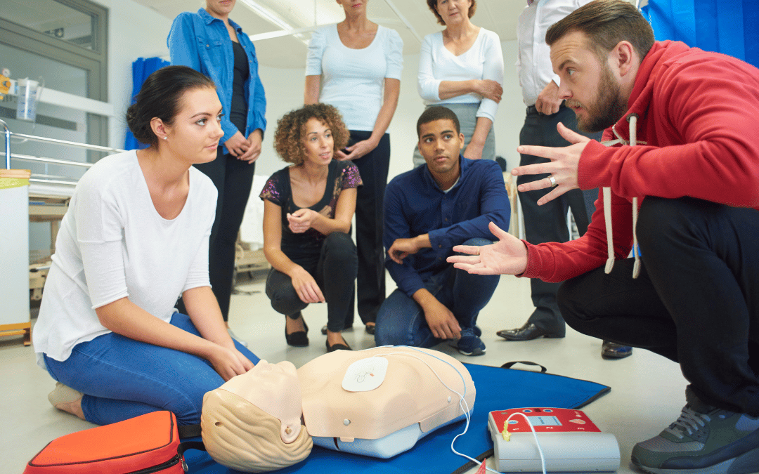 Instructor teaching healthcare workers how to use an AED in a BLS Certification class at A-B-CPR in San Diego