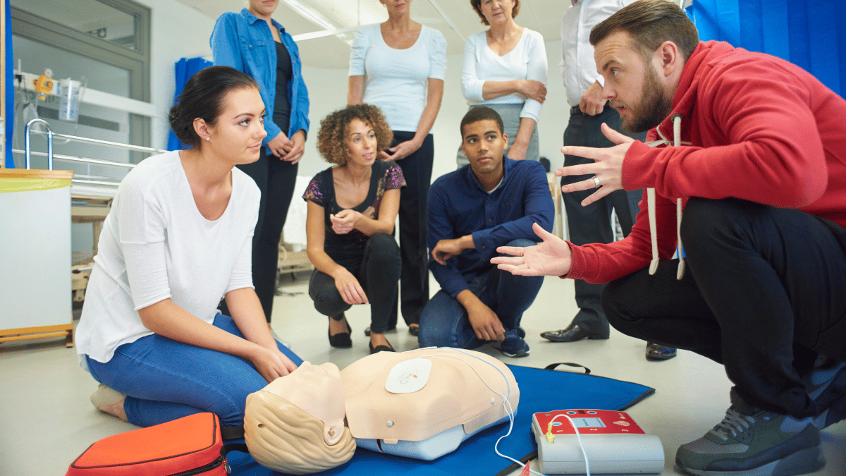 Instructor teaching healthcare workers how to use an AED in a BLS Certification class at A-B-CPR in San Diego
