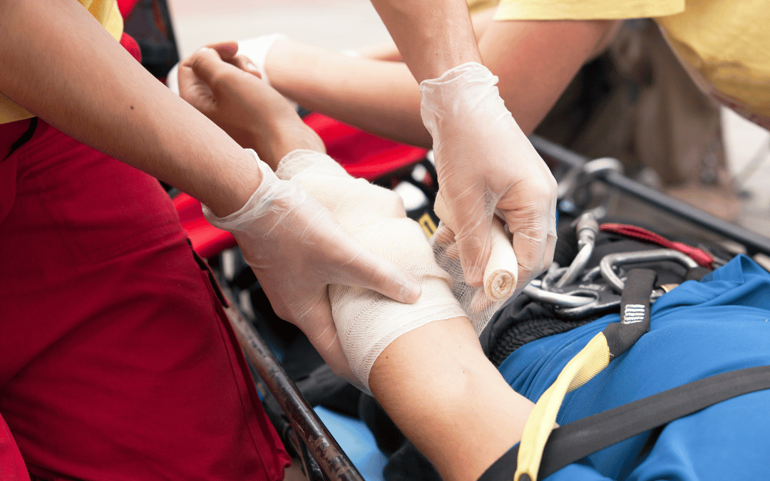 BLS-certified worker providing first aid by wrapping the arm of a patient in a rescue basket, showcasing skills learned during BLS renewal training.