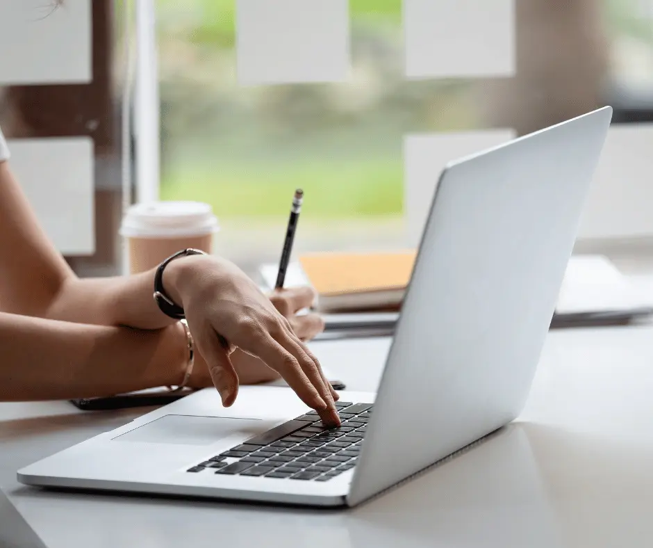 A person studying on a laptop while taking an online CPR and First Aid certification course.