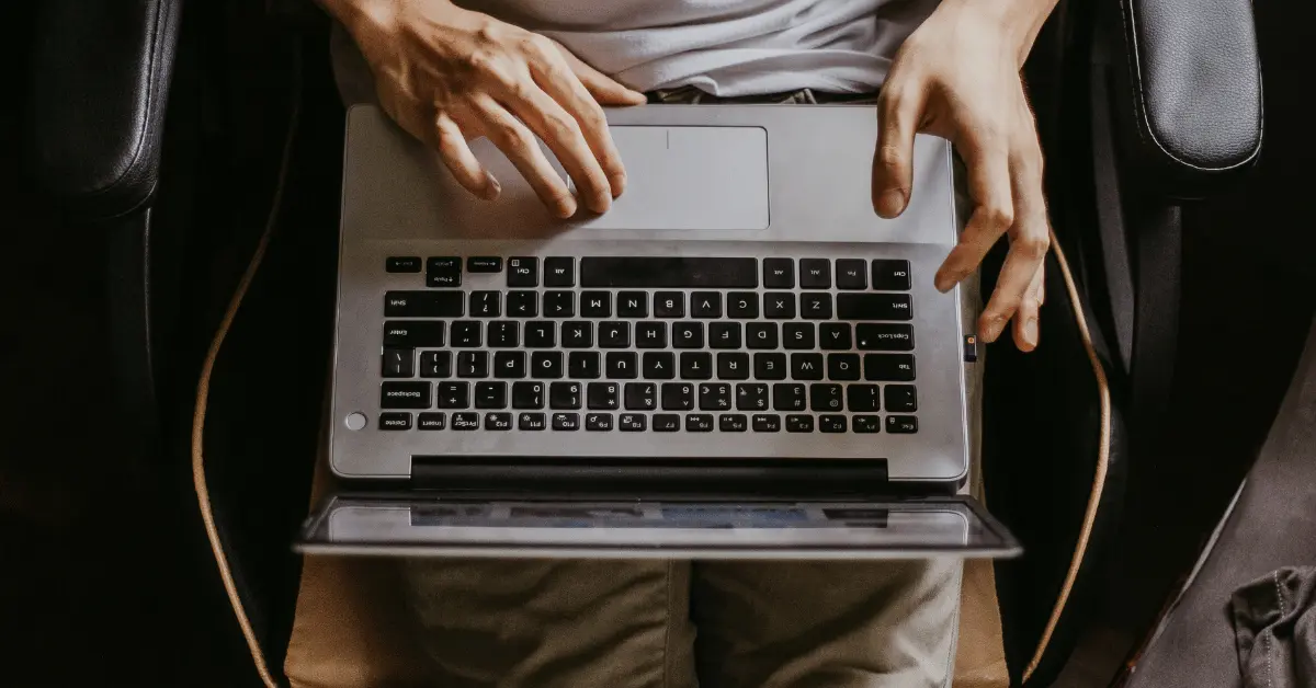 A person studying on a laptop from home while completing an online CPR and First Aid certification course.